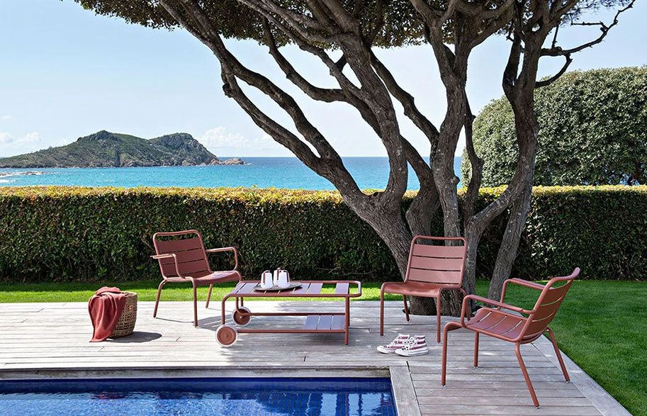 Chaise basse et fauteuil bas d'extérieur au bord d'une piscine d'hôtel